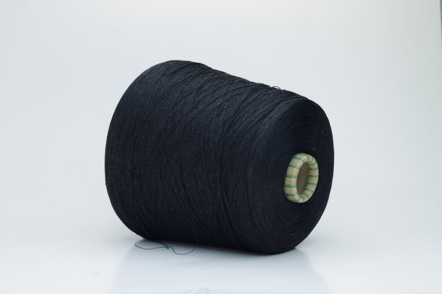 Spool of rich, deep black silk yarn, showcasing its fine, smooth plies and radiant, natural luster against a soft background.