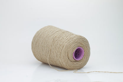 A luxuriously soft skein of pale, warm camel-colored cashmere yarn, gently twisted with a subtle halo, showcasing its delicate and fine fibers.