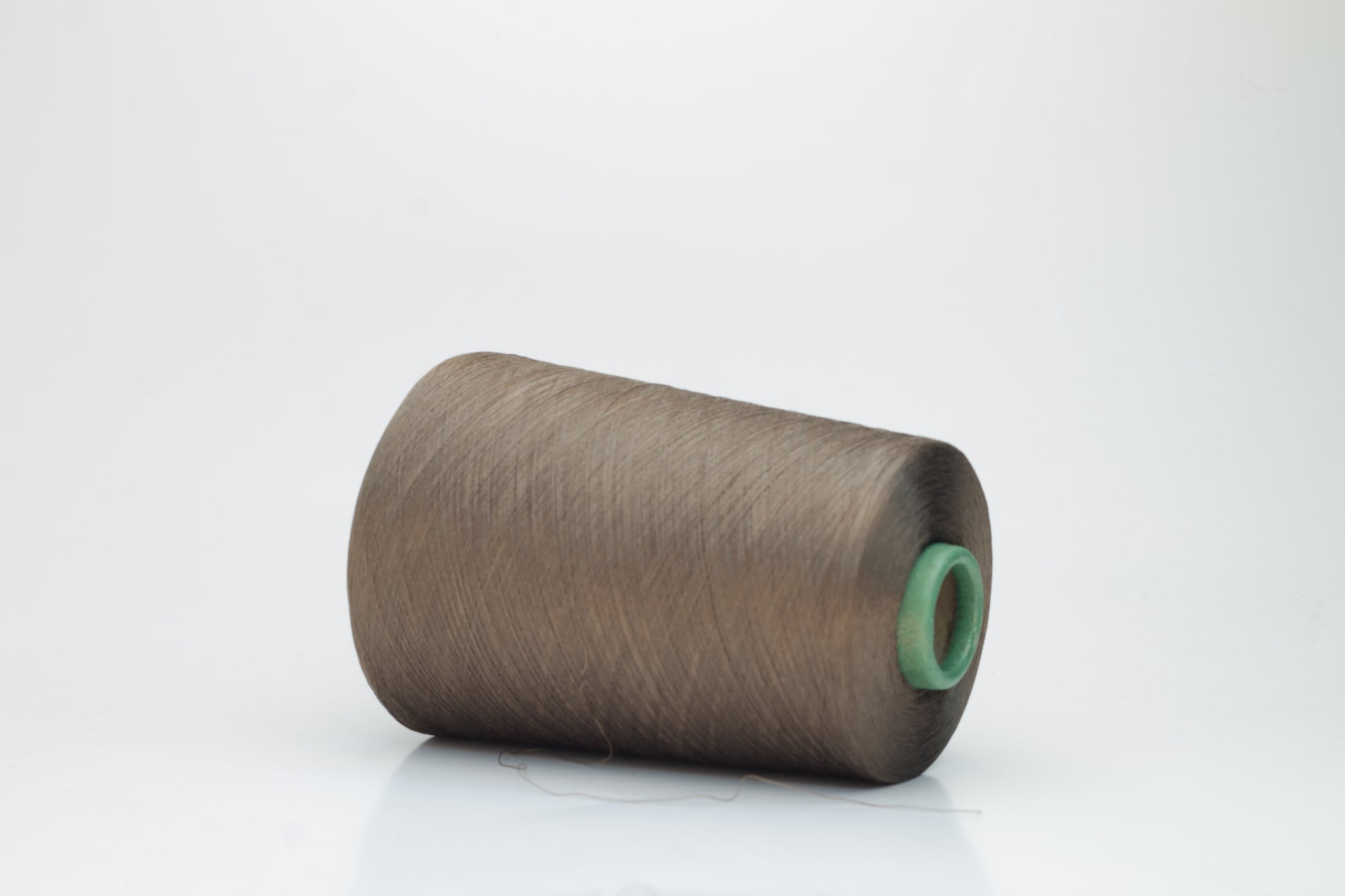 Finely spun, single-ply silk yarn in a deep, rich cacao brown, exhibiting a smooth, tight twist and brilliant, natural sheen.