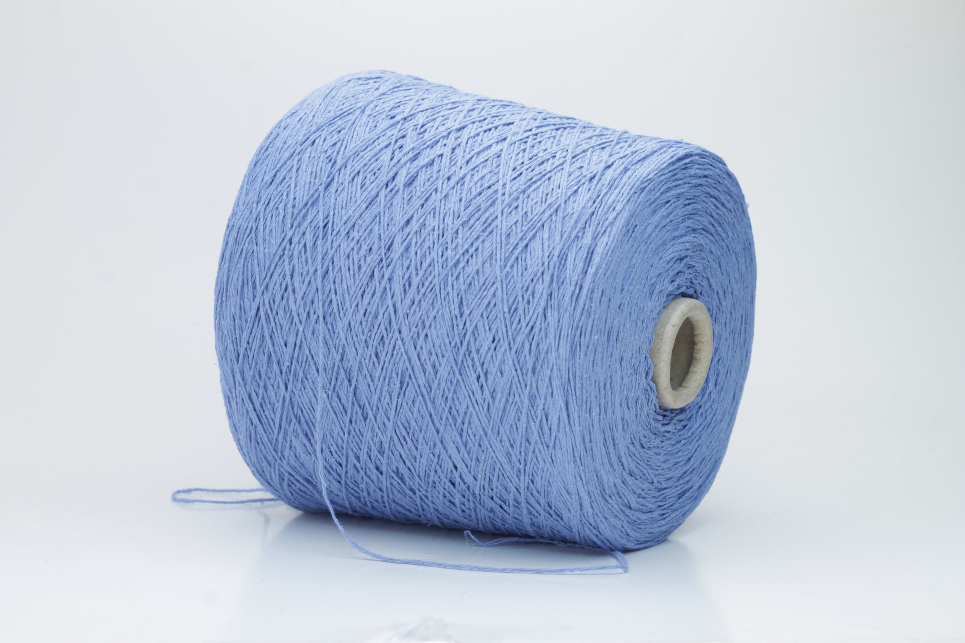 Close-up of a skein of deep Blue bourette silk yarn, showing its characteristic subtle slubs and matte texture, with a gentle, soft twist.
