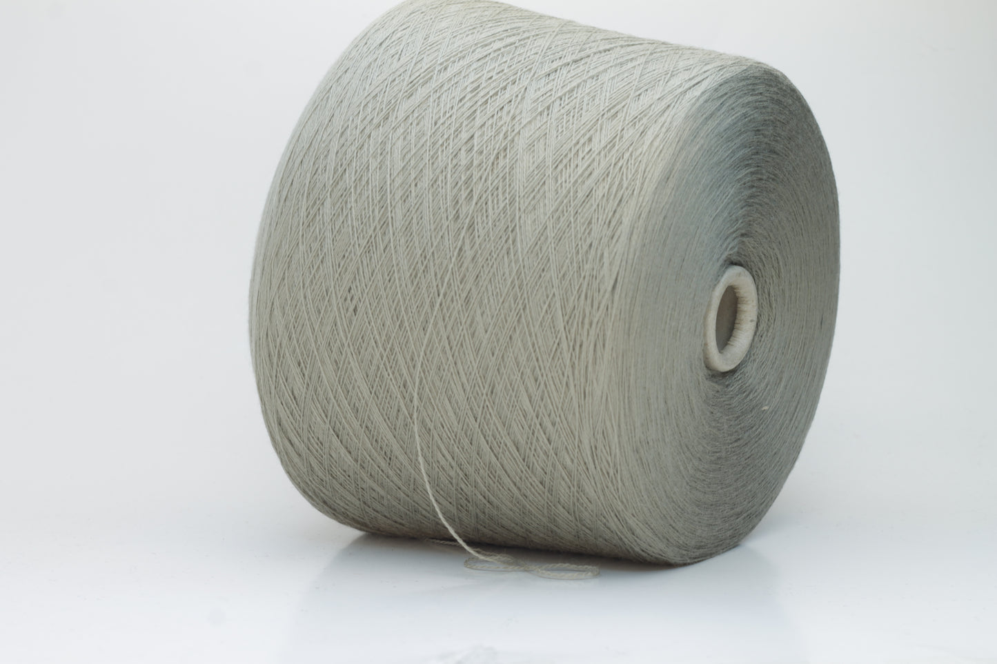 Close-up shot of the grey merino yarn, showcasing its fine 2/30 ply twist and subtle sheen, with a fluffy texture revealed through careful lighting.