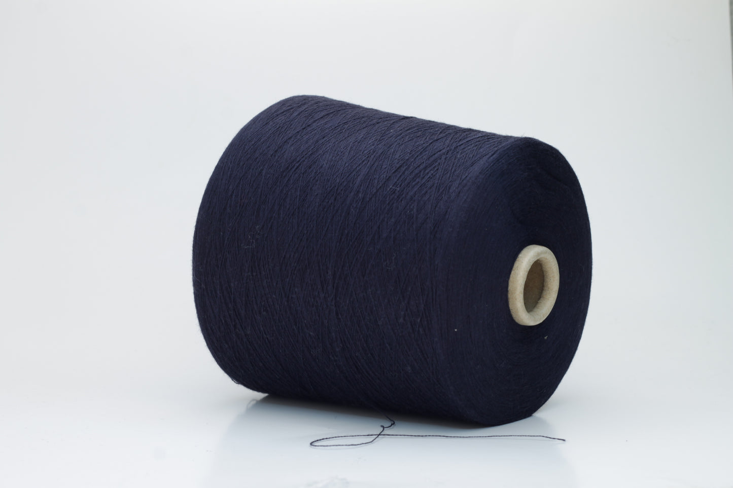 Close-up shot of dark blue, fluffy cotton 85% cashmere 15% yarn in a twisted ply, showcasing the fine thread structure and subtle sheen.