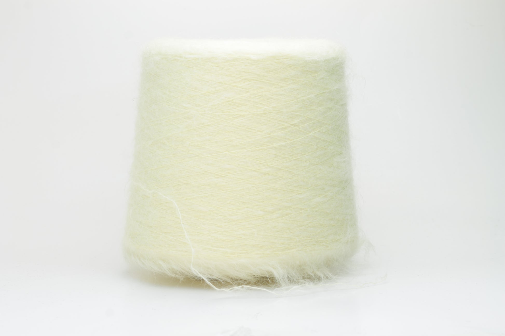 Close-up shot of SuperKidMohair yarn in Light Yellow, revealing a lustrous, fluffy texture with subtle sheen and a tight, well-defined ply twist.