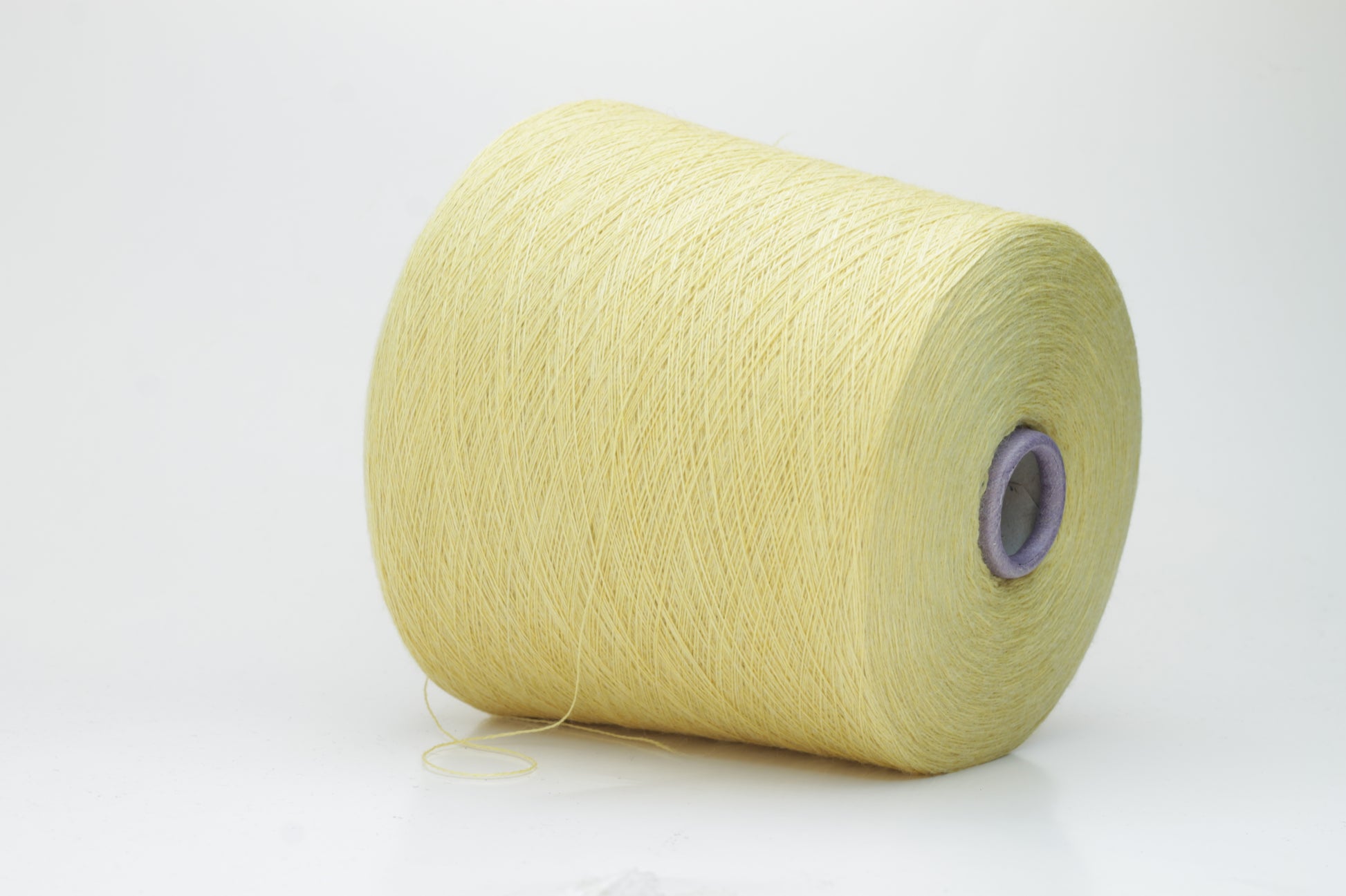 Close-up image of a vibrant yellow ZEGNA Baruffa merino yarn skein, showcasing its fine ply twist and dense thread structure with subtle sheen and inviting fluffiness.