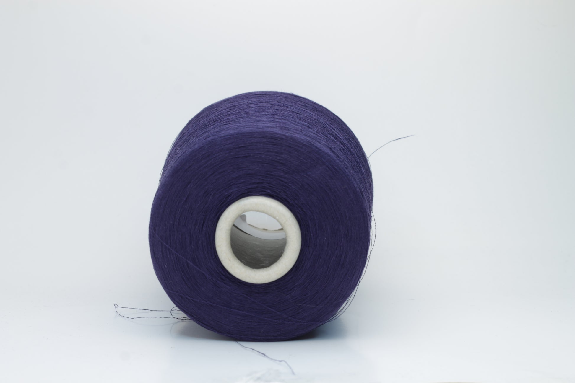 Close-up of a smooth, single-ply navy linen blend yarn, with a fine, crisp texture and subtle, natural sheen.