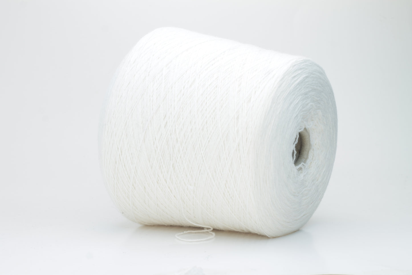 Close-up of a pure white cashmere yarn skein, showcasing its soft, slightly fluffy texture and subtle sheen with a gently twisted, fine two-ply structure.