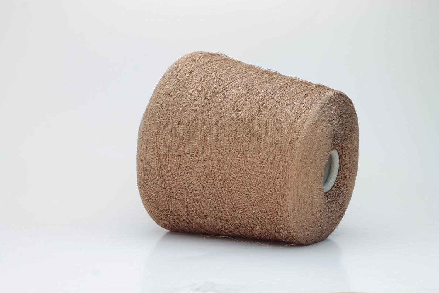 A finely spun, single-ply yarn in an earthy light brown hue, showcasing a delicate, rustic texture and a subtle, natural matte sheen.