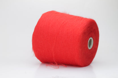 Close-up view of vibrant red SuperKidMohair yarn featuring a dense, fluffy pile with subtle sheen. The ply twist is evident in the slightly twisted structure, creating a soft and luxurious tactile experience.