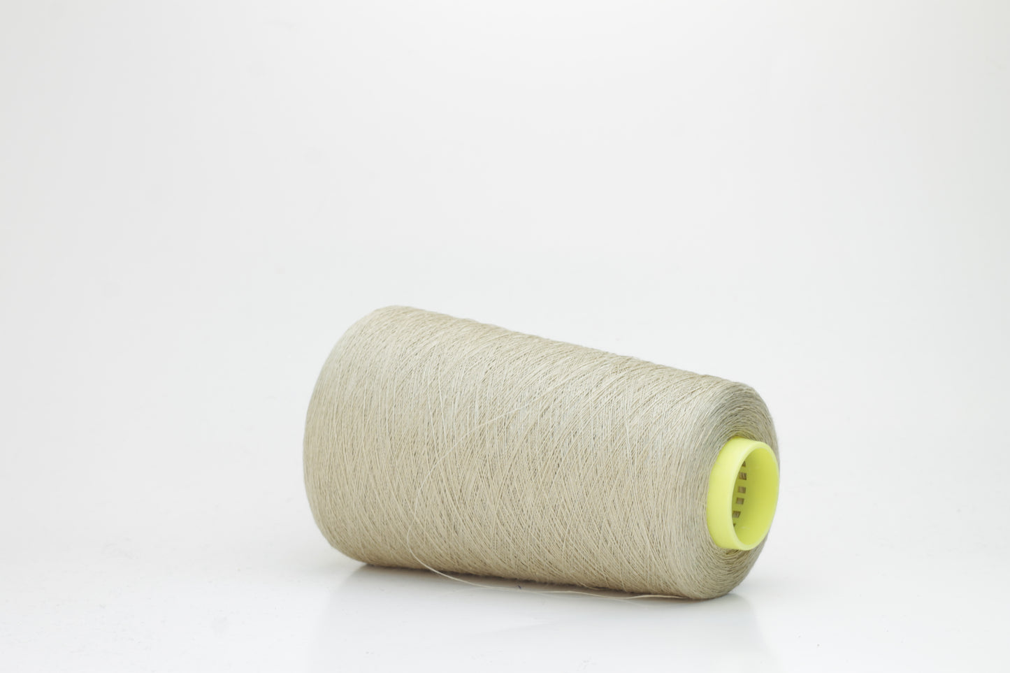 Fine, single-ply linen yarn in a rich Pale Oatmeal. Reveals a crisp texture and subtle natural sheen, typical of pure linen fiber.