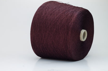 Close-up of a neatly wound cone of deep wine-red 2-ply linen yarn, exhibiting a subtle natural sheen and distinct crisp texture.