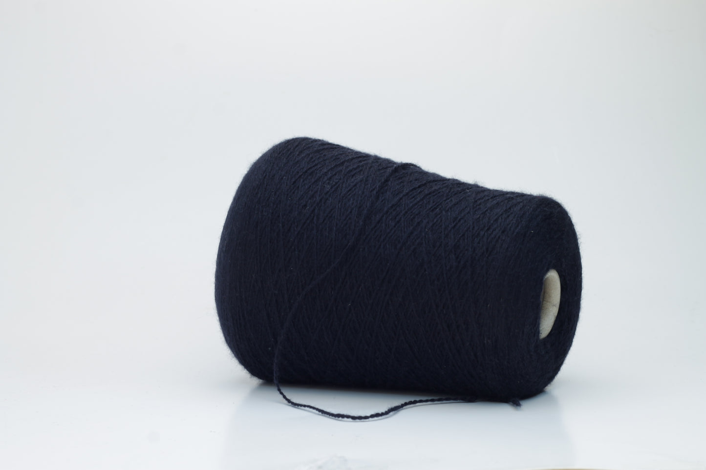 Luxurious, evenly spun two-ply yarn in a deep, rich matte navy blue. The cashmere fibers exhibit a soft halo and subtle natural sheen.