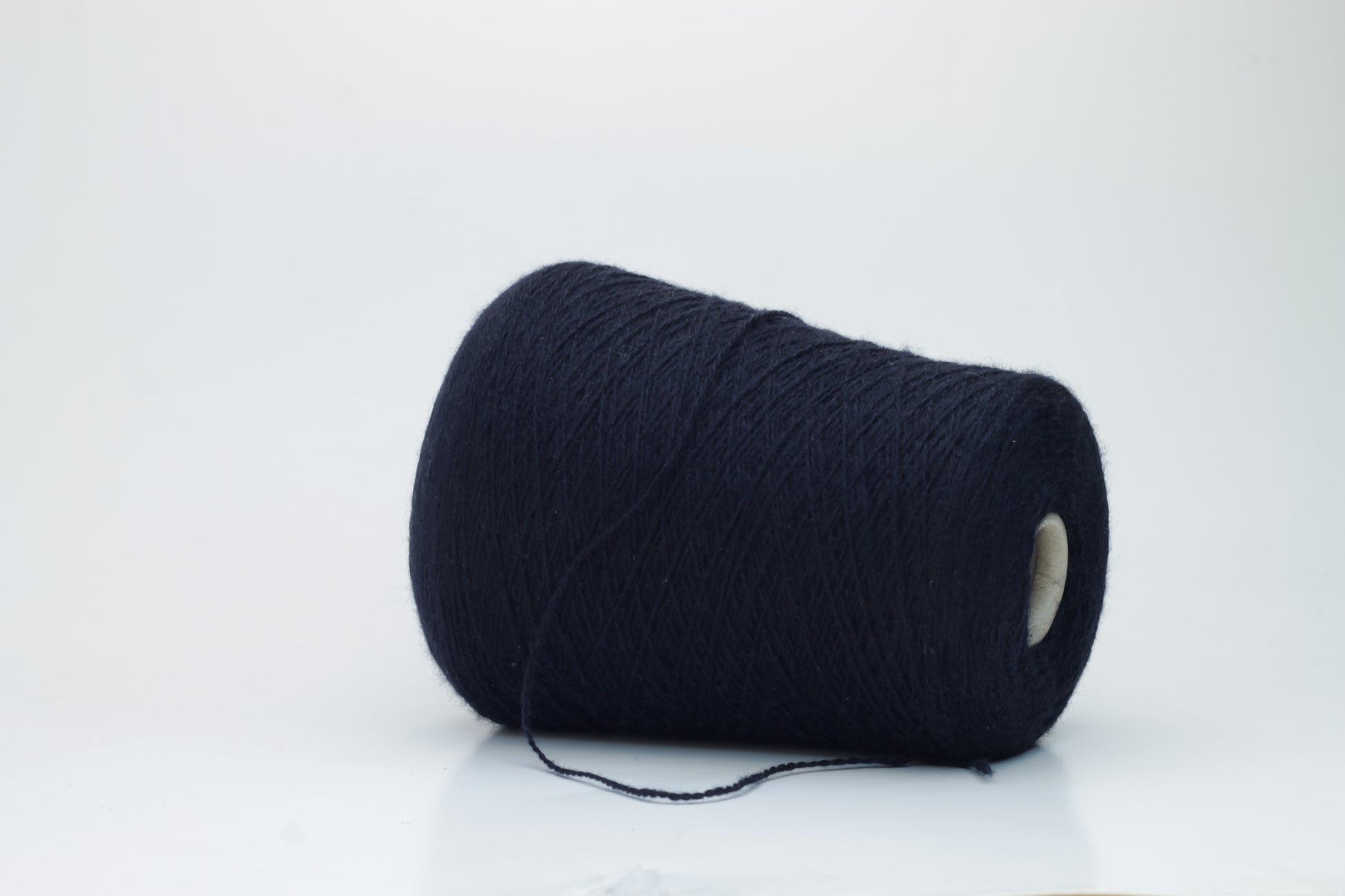 Luxurious, evenly spun two-ply yarn in a deep, rich matte navy blue. The cashmere fibers exhibit a soft halo and subtle natural sheen.