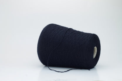 Luxurious, evenly spun two-ply yarn in a deep, rich matte navy blue. The cashmere fibers exhibit a soft halo and subtle natural sheen.