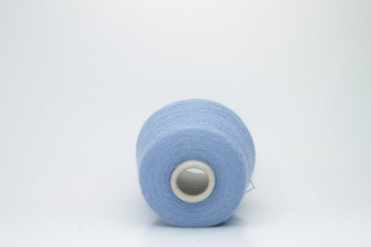 Close-up of a skein of soft, plied alpaca merino yarn in a deep forest green, showing subtle sheen and fine fiber halo.
