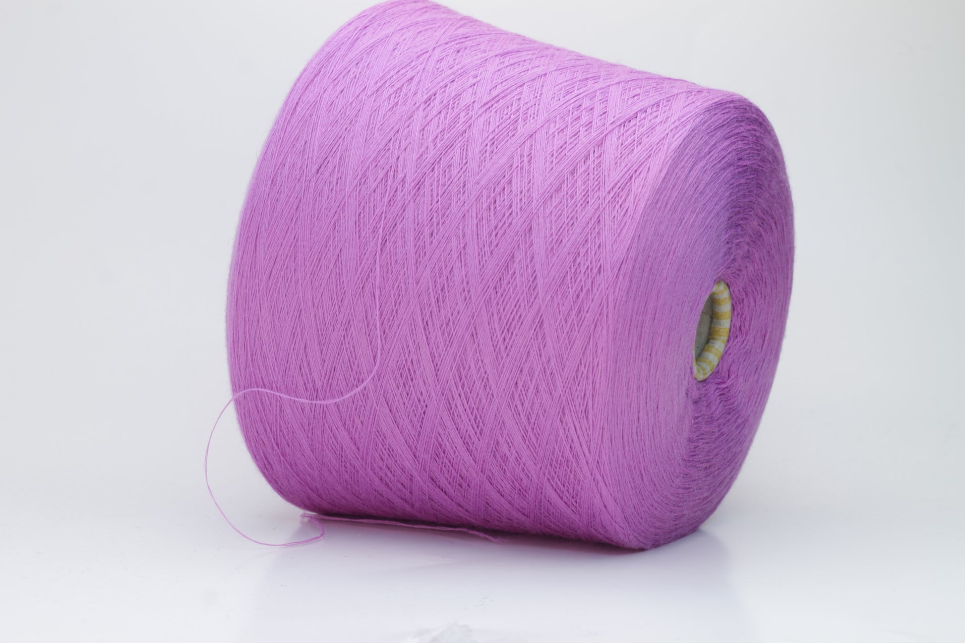 Close-up image showcasing a vibrant purple 100% merino yarn skein with a slight twist, revealing the fine ply structure and rich color depth; the fiber appears fluffy and soft.