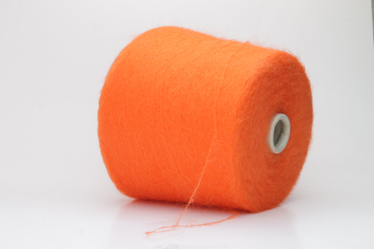 Close-up shot of vibrant orange SuperKidMohair yarn, displaying a tight ply twist and a rich, fluffy texture with noticeable sheen.