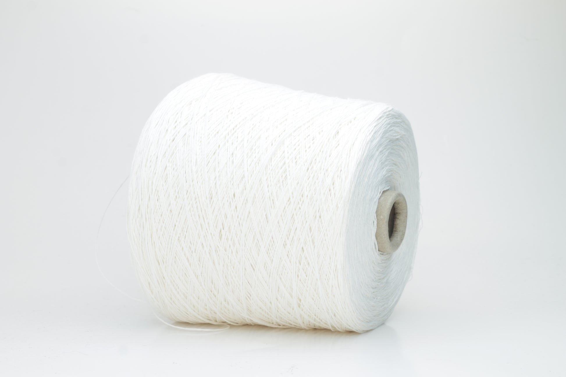 Close-up of pristine white linen and viscose blend yarn, softly twisted with a subtle sheen, showcasing its fine, smooth texture.