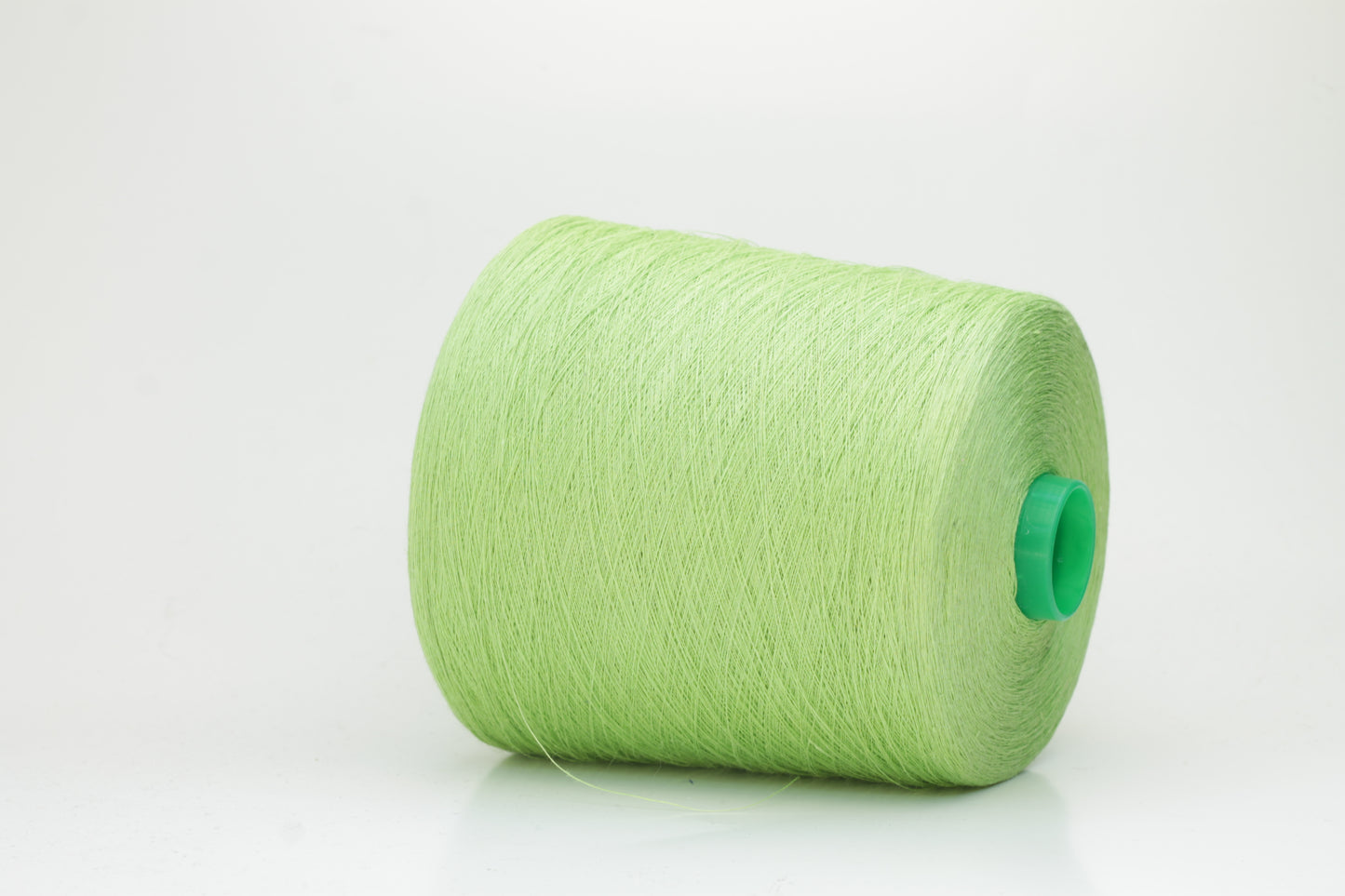 Fine, single-ply linen yarn in a rich Light Apple Green. Reveals a crisp texture and subtle natural sheen, typical of pure linen fiber.