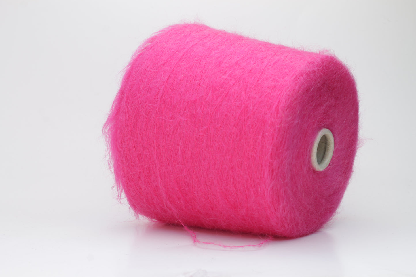 Close-up view of SuperKidMohair yarn in Fuxia, showcasing its fluffy texture and slightly twisted ply structure with subtle sheen.