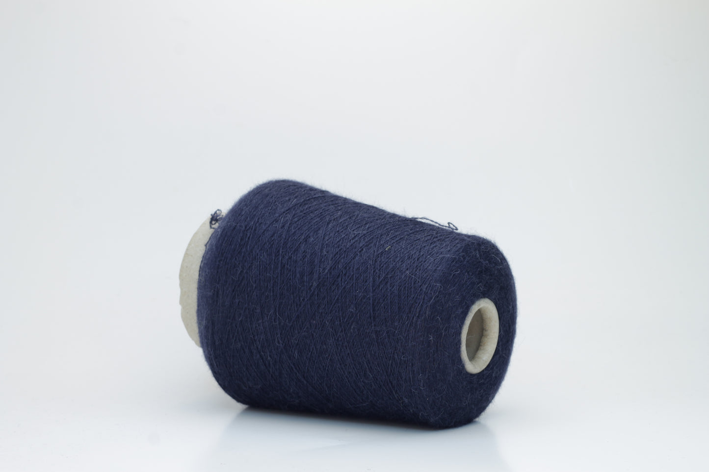 Close-up of Quipa Nm 2/28 Alpaca Merino yarn, showing its soft, slightly diffused fibers and a tight, even two-ply twist in a rich, dark navy hue.