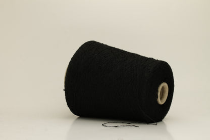 Close-up of a Black, textured Nodino yarn, showing subtle, irregular nubs and a soft, matte sheen; twisted ply visible.
