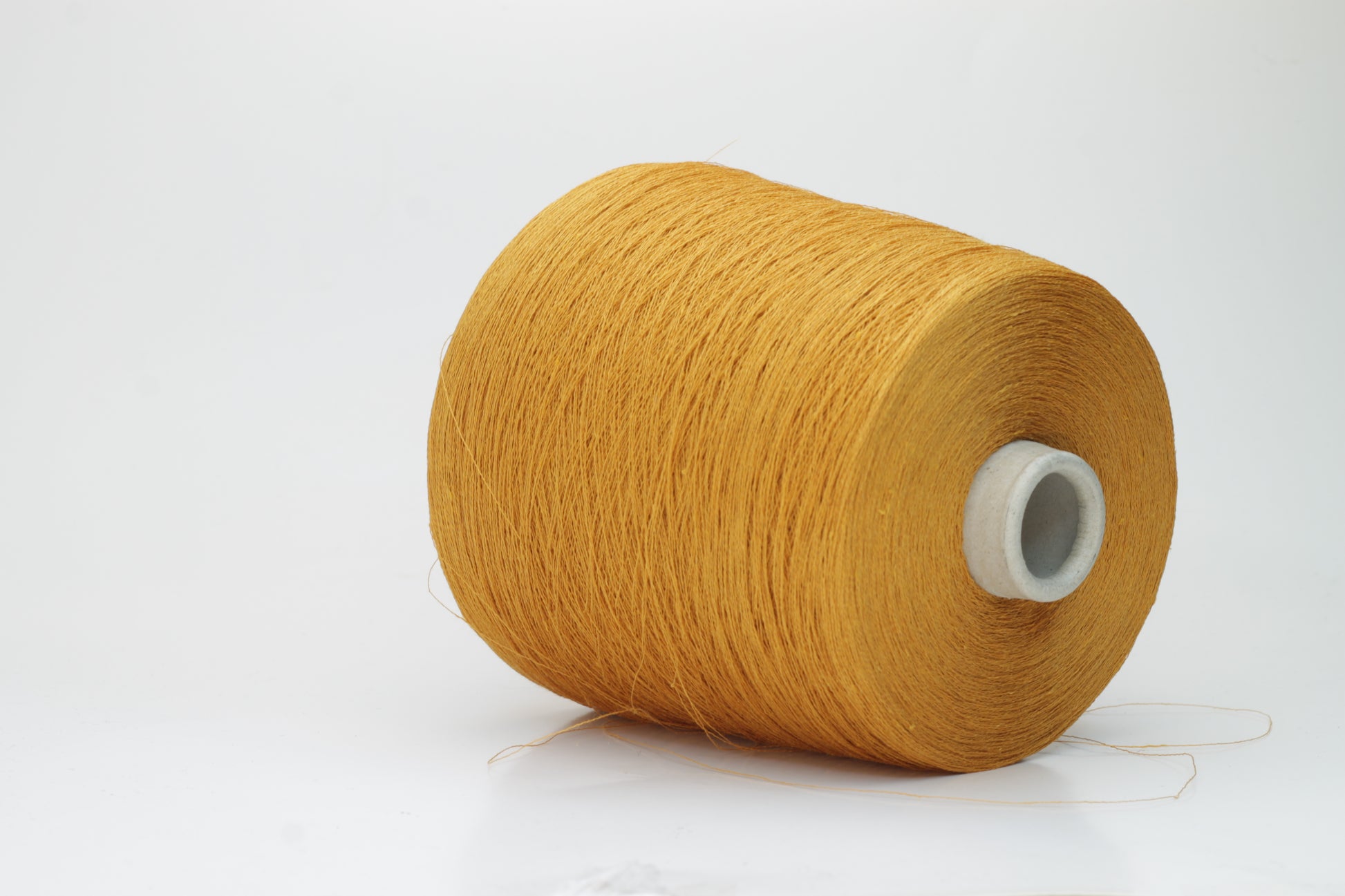Close-up of a finely spun, vibrant orange yarn with a subtle, natural sheen. Its multi-filament structure shows a delicate twist, offering both crispness and soft resilience, suitable for textile artistry.