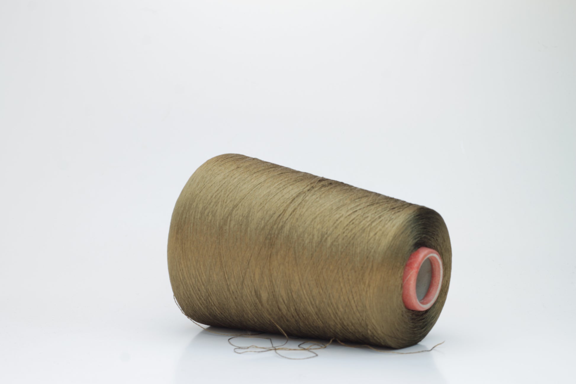 Close-up of a spool of finely twisted, single-ply Organzino silk yarn in a deep, lustrous bronze hue, catching light with a subtle, elegant sheen.