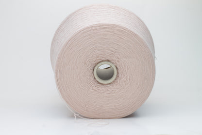 Soft, slightly fuzzy two-ply cashmere yarn in a muted, warm dusty rose color with a subtle sheen, loosely wound in a skein.