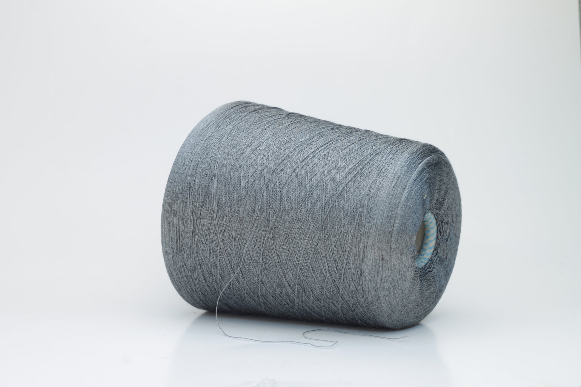 Close-up of a meticulously twisted two-ply 100% silk yarn, revealing a subtle, sophisticated medium gray hue with a natural, elegant sheen.