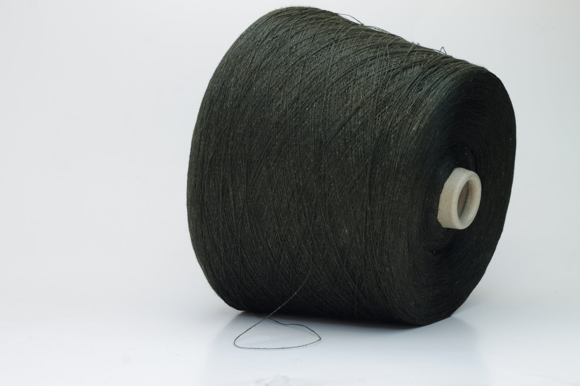 Two plies of earthy Cicoria brown linen yarn, tightly twisted with visible fibers, showcasing natural slubs and a subtle, sophisticated sheen.