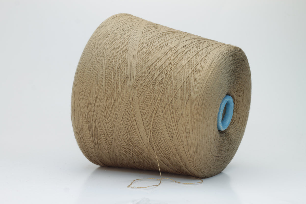 Close-up shot of a cone of creamy camel colored 100% merino yarn, showcasing the fine ply twist and subtle sheen of the fibers.