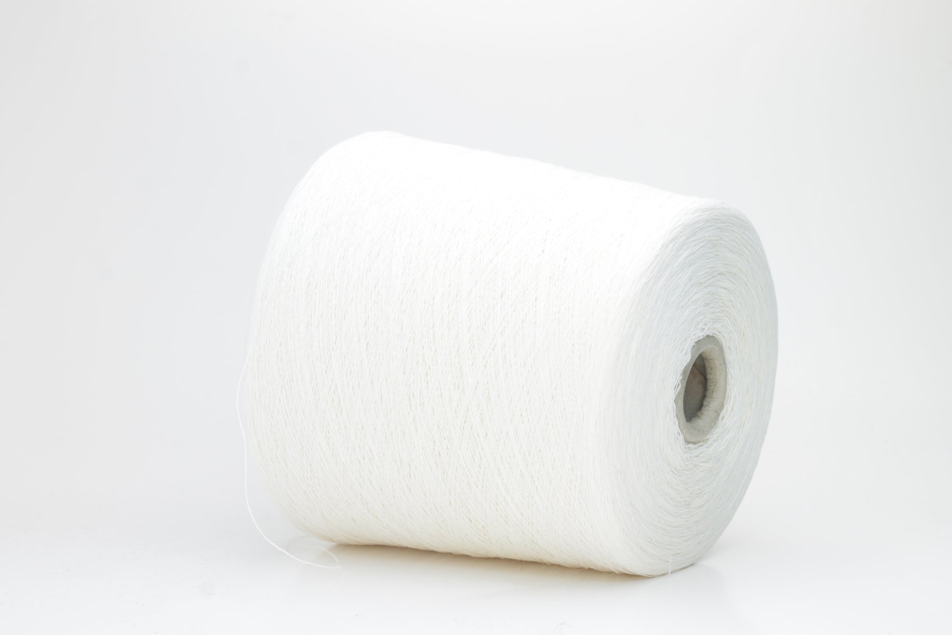 A soft white three-ply linen yarn, tightly twisted with a subtle natural sheen, presented in a neatly wound skein, showcasing its crisp, cool texture.