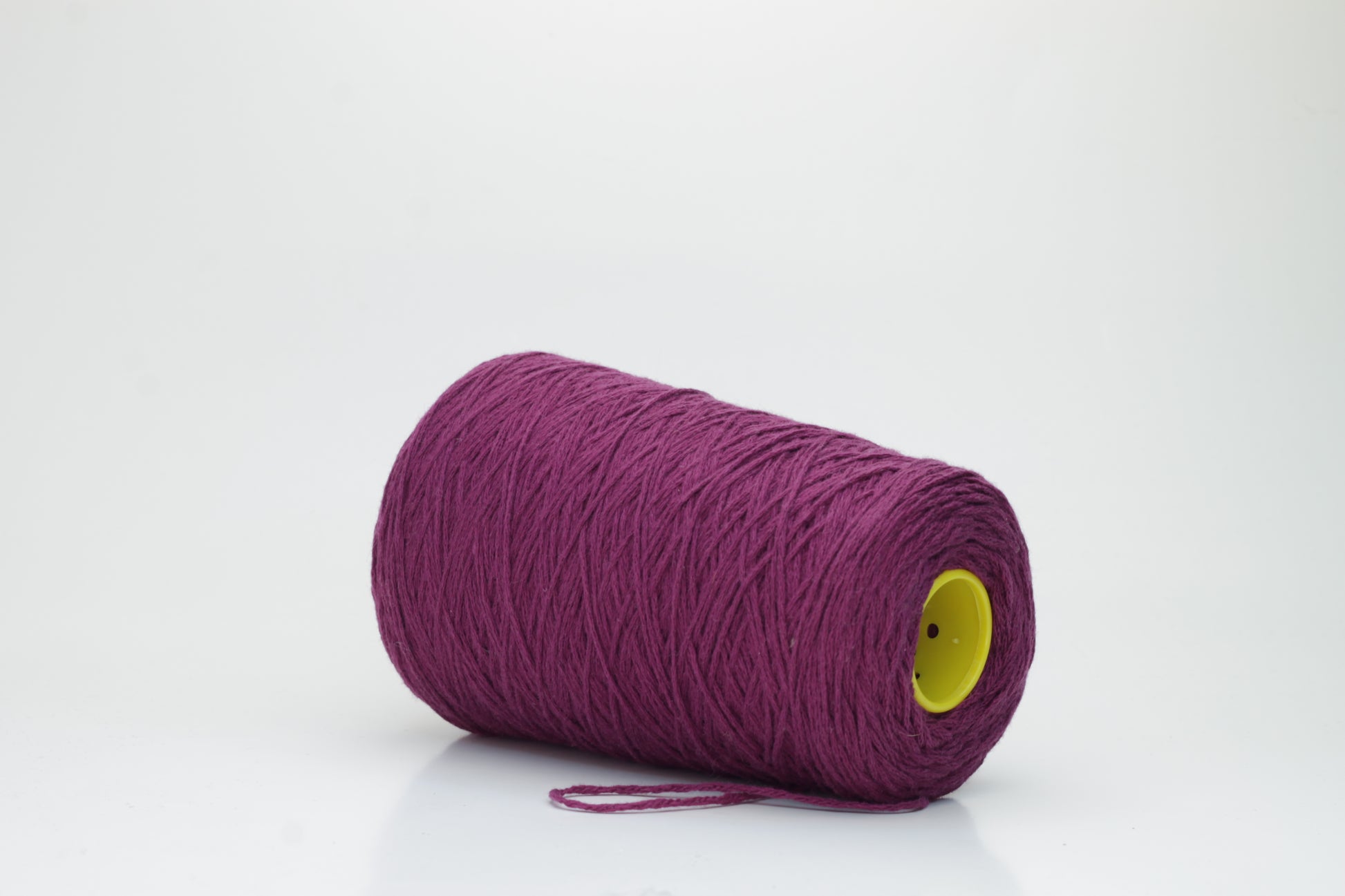 Close-up of soft, lustrous pure cashmere yarn, gently twisted, revealing a rich, deep anemone purple with a subtle, velvety halo.