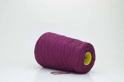 Close-up of soft, lustrous pure cashmere yarn, gently twisted, revealing a rich, deep anemone purple with a subtle, velvety halo.