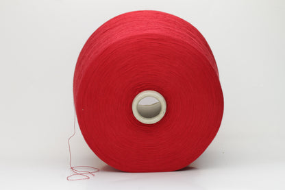 Close-up of a vibrant, rich red cotton yarn. The smooth, tightly twisted 2-ply thread exhibits a subtle sheen and deep, saturated color.