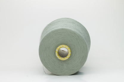 Close-up of a finely twisted Nm 2/50 cotton yarn in a muted, sophisticated sage green heather, exhibiting a subtle matte sheen and uniform ply.