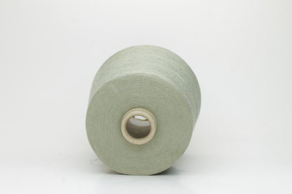 A finely spun, lustrous two-ply cotton yarn in a muted, earthy soft sage green, showcasing a gentle twist and smooth finish.