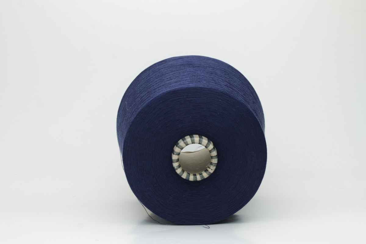 Close-up of a meticulously twisted, fine-gauge cotton yarn in a deep, lustrous classic navy blue with a subtle sheen.