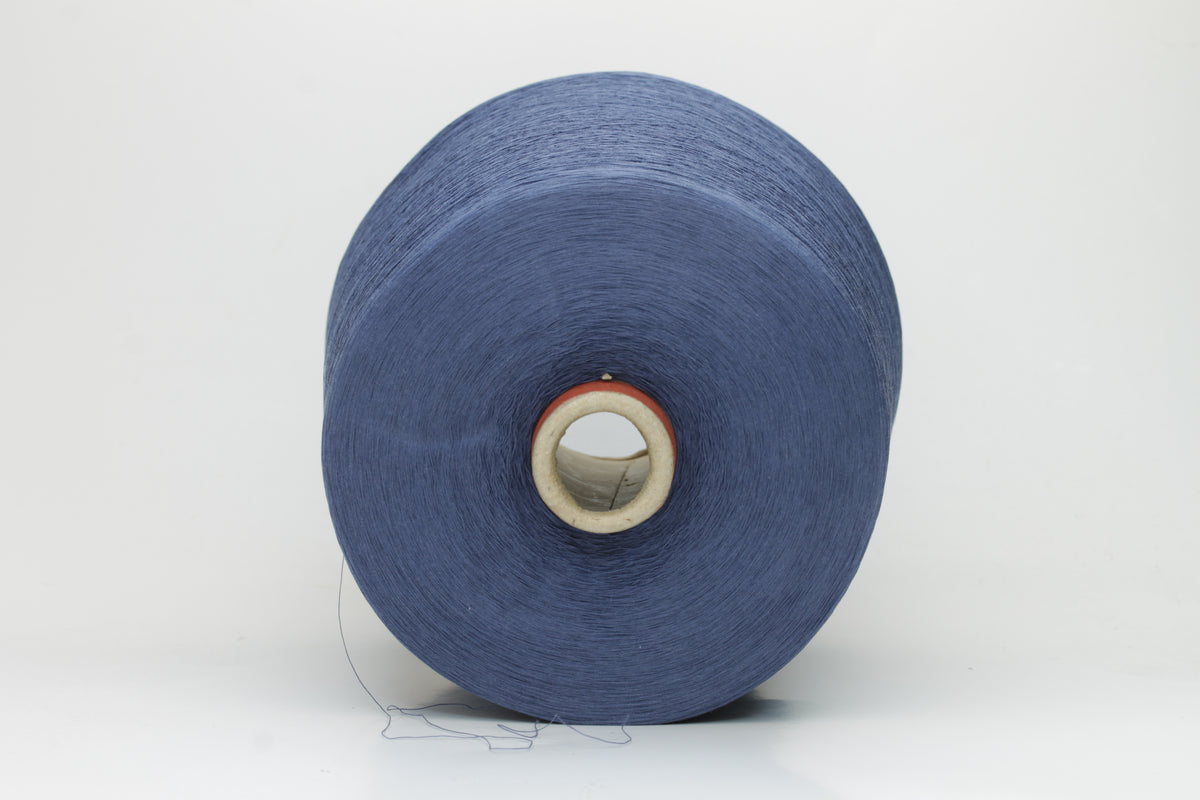 Close-up of finely spun, matte-finish cotton yarn in a rich, multi-toned classic denim blue heather, revealing subtle variations and a smooth, consistent two-ply twist.