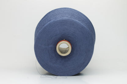 Close-up of finely spun, matte-finish cotton yarn in a rich, multi-toned classic denim blue heather, revealing subtle variations and a smooth, consistent two-ply twist.