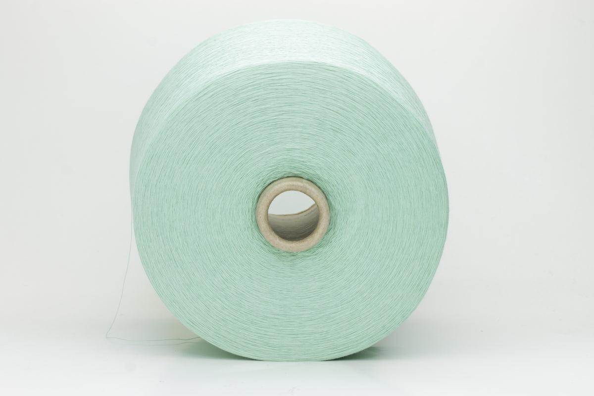 A finely spun, smooth cotton yarn in a delicate pastel mint green color, showing a subtle sheen and tightly plied structure.