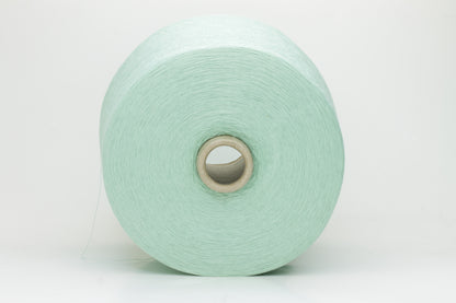 A finely spun, smooth cotton yarn in a delicate pastel mint green color, showing a subtle sheen and tightly plied structure.