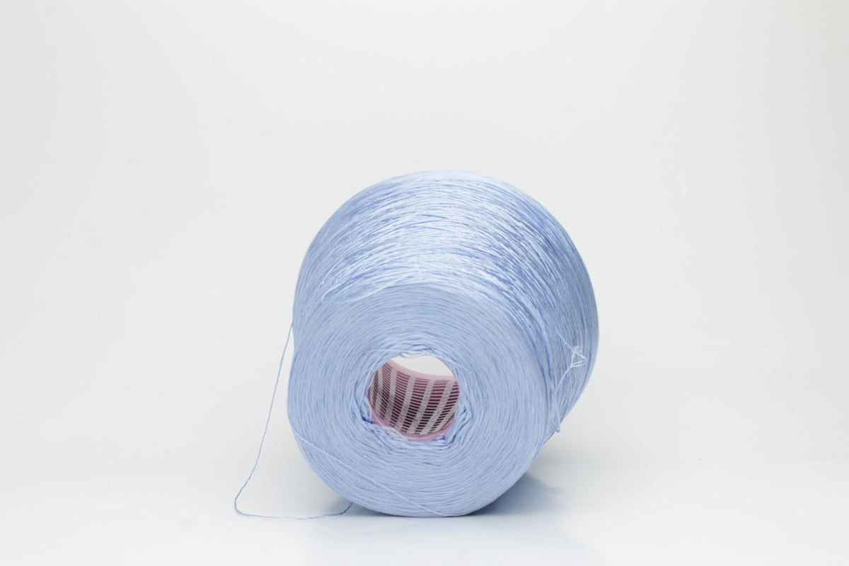 Close-up of extremely fine, single-ply pure silk yarn in a pale, iridescent sky blue. It has a high natural sheen and smooth, uniform texture.