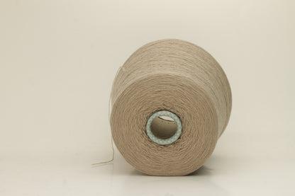 Close-up of a skein of incredibly soft, two-ply cashmere yarn in a deep, warm Mastice beige. Fine fibers with a subtle halo and elegant twist visible.