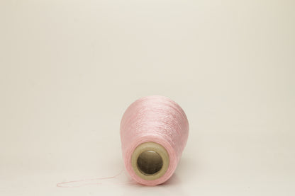 Close-up of pristine Rosa, finely plied 100% silk yarn, twisted smoothly to reveal a high, lustrous sheen and uniform structure.