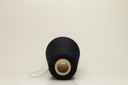 A skein of fine, single-ply 100% silk yarn, lustrous with a deep, rich dark midnight blue hue, reflecting light softly.