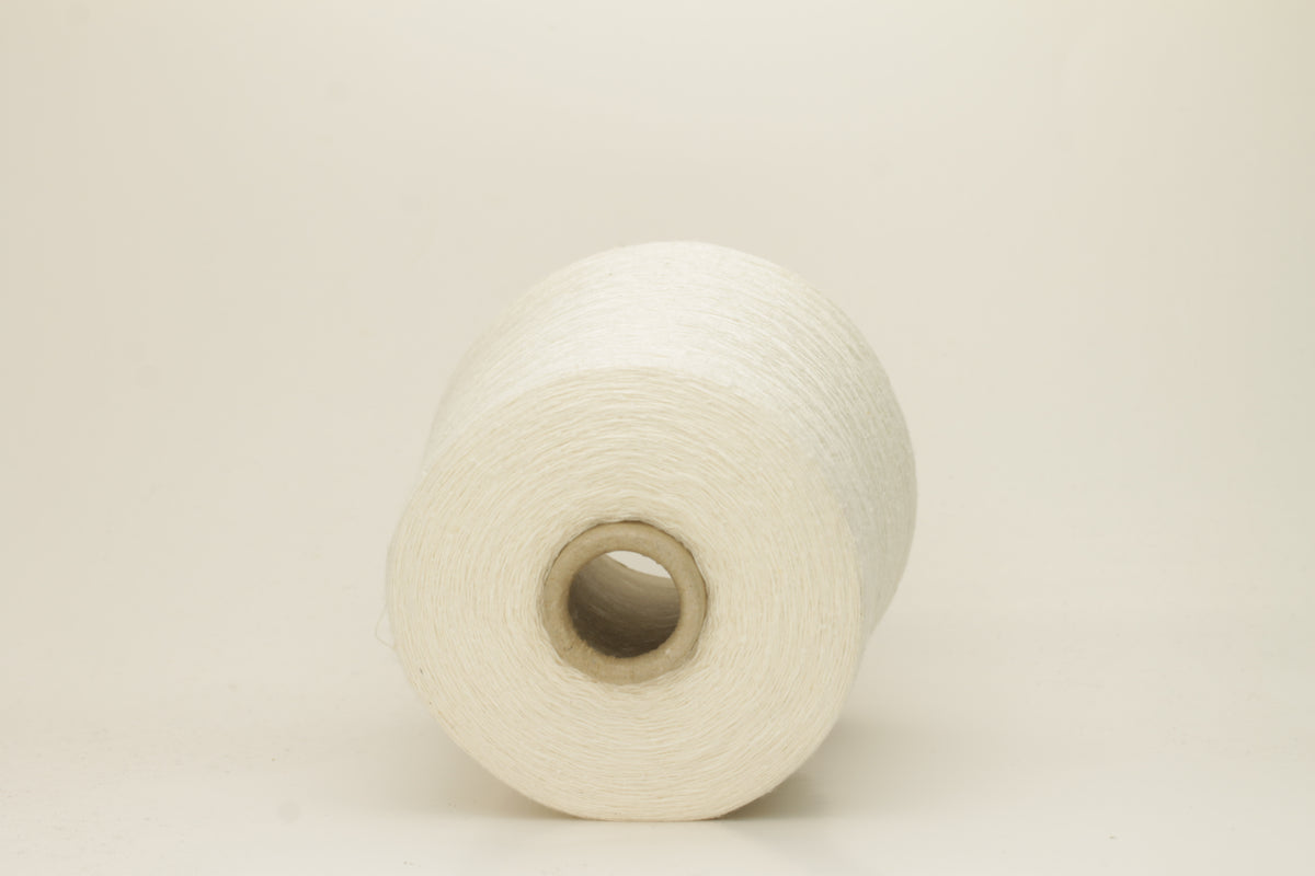 A tightly twisted single strand of luxurious deep royal blue silk yarn, reflecting light with a soft, natural sheen.