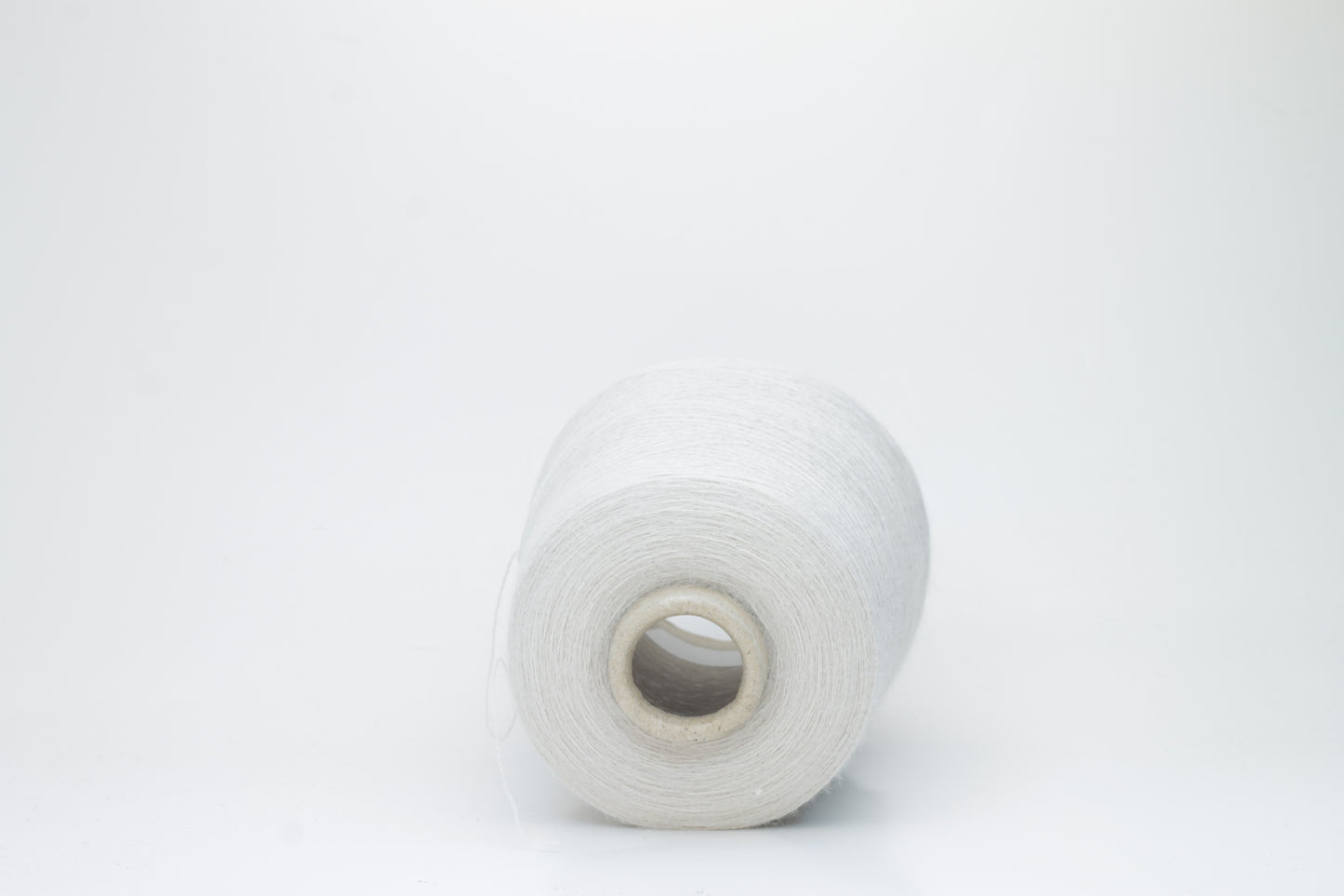 Close-up of lustrous beige 2-ply alpaca merino yarn, subtly twisted with a fine, even structure and soft, low halo.