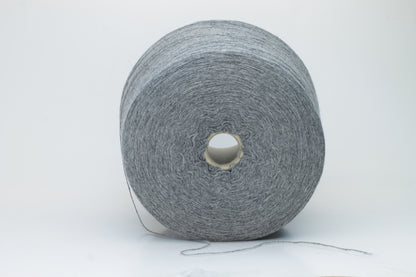 Skein of fine, two-ply cashmere yarn in a sophisticated medium gray, exhibiting a soft, subtle halo and delicate matte sheen.