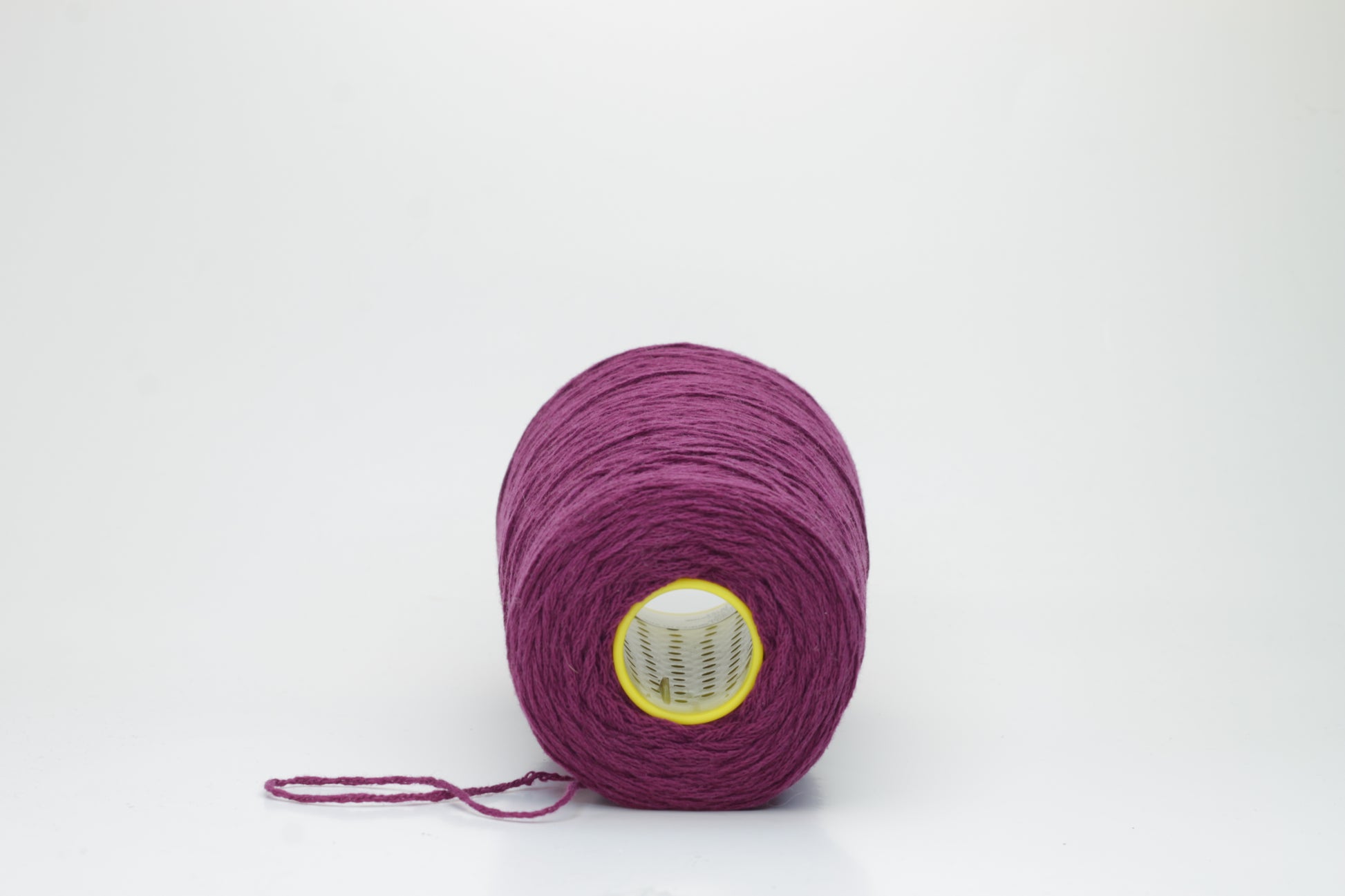 Close-up of soft, lustrous pure cashmere yarn, gently twisted, revealing a rich, deep anemone purple with a subtle, velvety halo.